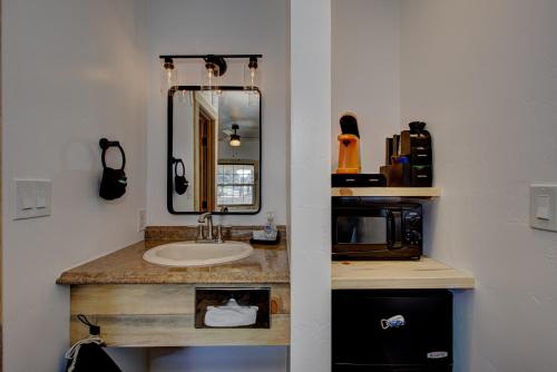 a bathroom with a sink and a mirror and a microwave at Alpine Lodge Hotel in Cascade