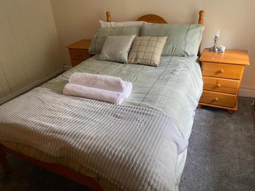 a bedroom with a bed with two towels on it at Traditional 3-Bed Cottage sea mountain views in Falcarragh