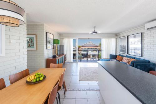 a kitchen and living room with a table with fruit on it at The Springs - oceanstays in Yamba