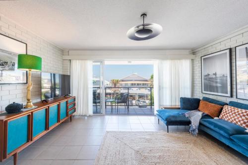 a living room with a blue couch and a tv at The Springs - oceanstays in Yamba