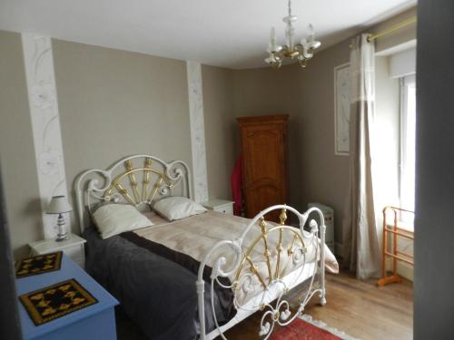 a bedroom with a bed and a chandelier at Les Gîtes Cancalais in Cancale