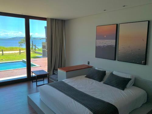a bedroom with a bed and a view of the ocean at Lagoon Suites e Gastronomia in Laguna