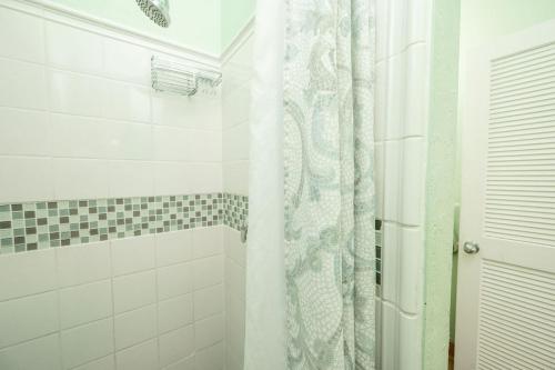 a bathroom with a shower with a shower curtain at The Speakeasy Inn and Rum Bar in Key West