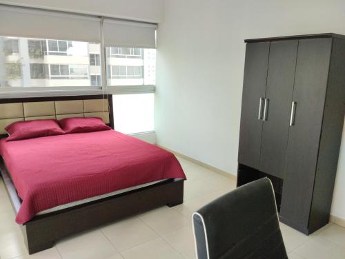 een slaapkamer met een bed, een kast en een stoel bij Yc l Estudio av Balboa - GB701A in Panama-Stad