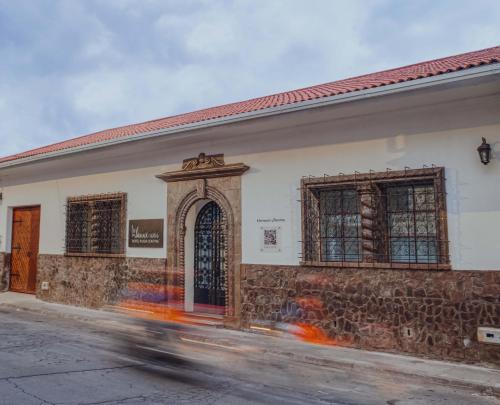 a building on a street with a car driving past it at Wanderlot - Hotel Plaza Central in Riobamba