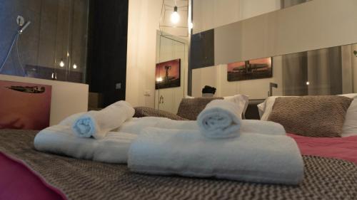 Una cama con toallas encima. en XENIA LUXURY ROOMS en Reggio Calabria