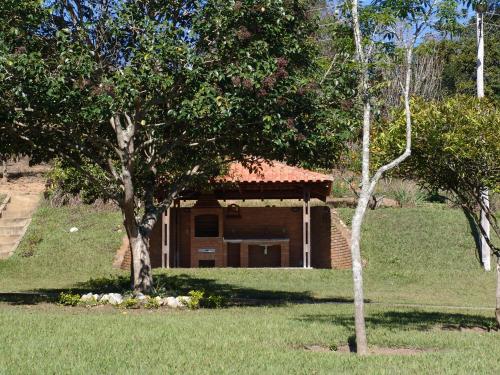 una piccola casa in un cortile con due alberi di Sitio Vale do Sol -Seu Descanso recarregando energias a Itajubá