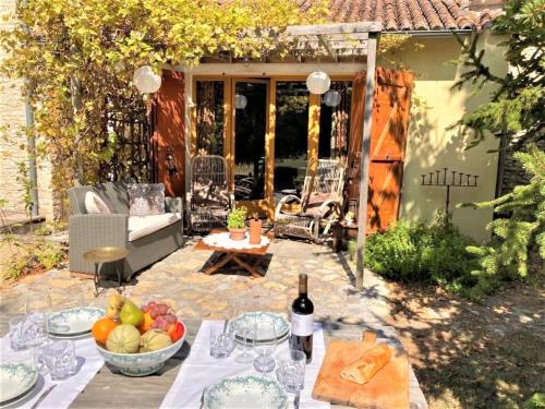 een tafel met een fruitschaal op een patio bij Heritage cottage near the forest in Frontenay-sur-Dive