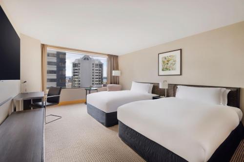 um quarto de hotel com duas camas e uma janela em JW Marriott Auckland em Auckland