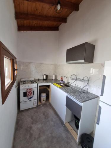 a small kitchen with a stove and a sink at Calahue Apart in Trevelin