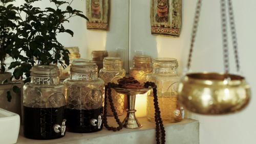a bunch of glass jars on a shelf with a plant at KAMENOI HOTEL Atami in Atami