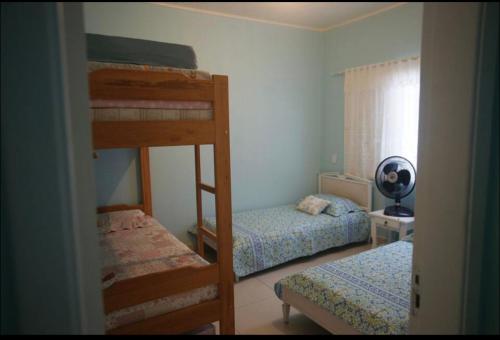 ein Schlafzimmer mit zwei Etagenbetten und einem Fenster in der Unterkunft Beach House in Ubatuba