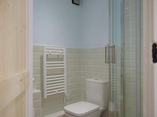 a bathroom with a toilet and a glass shower at The Granary in Clee Saint Margaret