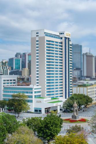 a large building with a statue in front of a city at Guangzhou Hotel in Guangzhou