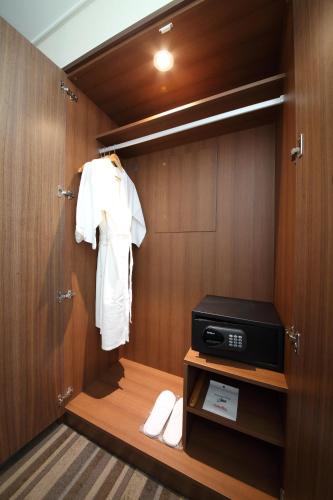 a bathroom with a closet with a robe on a door at Avonhotel Gunsan in Gunsan