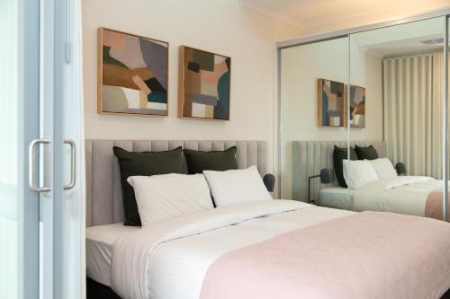 a bedroom with two beds and a mirror at Hilton Executive Apartments in Keswick