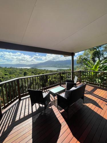 a deck with chairs and a table on a balcony at Whitsundays Bayview Escape in Cannon Valley