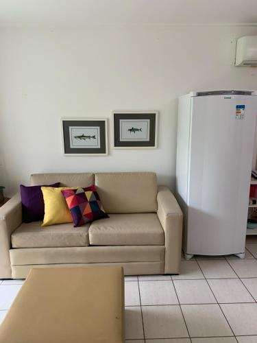 a living room with a couch and a refrigerator at Flat Beach Class Resort Muro Alto in Porto De Galinhas