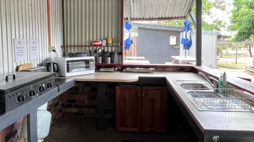 a kitchen with a sink and a microwave on a counter at Mingling Waters in Nowa Nowa