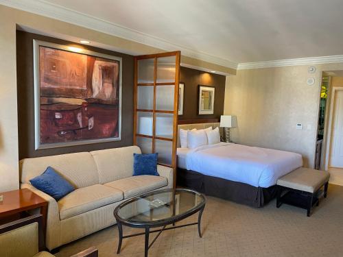 a hotel room with a bed and a couch at MGM SIGNATURE - Balcony Suite Strip View - FREE valet parking in Las Vegas