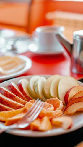 a plate of fruit with a fork on a table at Hotel Spa Nieves Del Cerro in Caviahue