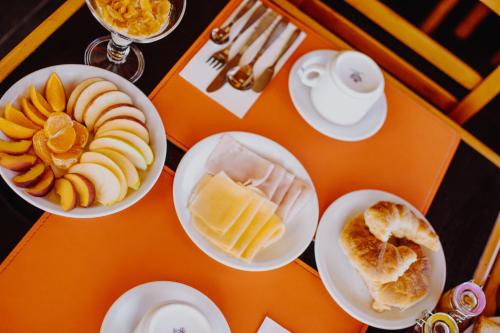 an orange table with plates of food on it at Hotel Spa Nieves Del Cerro in Caviahue