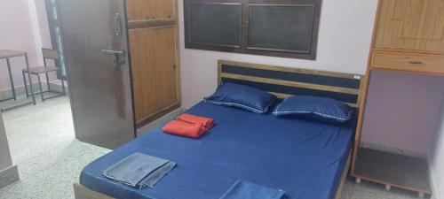 a blue bed with blue pillows and a red pillow at Doctor's Homestay in Tiruvannāmalai