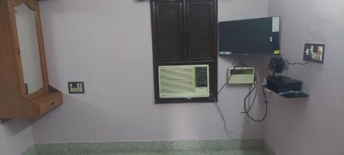 a room with a wall with a tv and a telephone at Doctor's Homestay in Tiruvannāmalai