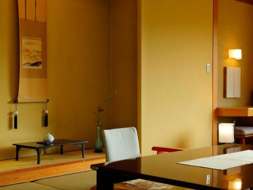 uma sala de estar com uma mesa e uma cadeira em Taishoya em Ureshino
