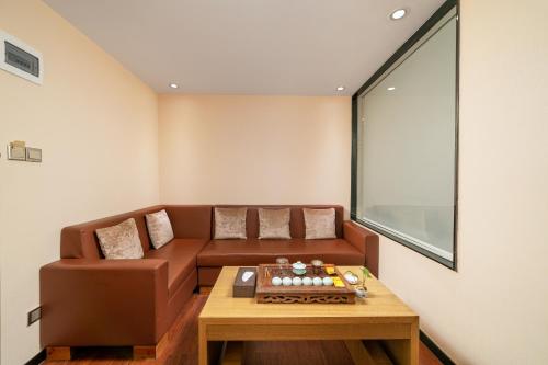 a living room with a brown couch and a table at Guangzhou Boyi Hotel in Guangzhou