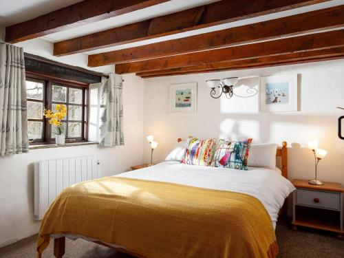 a bedroom with a large bed with a yellow blanket at Beech Cottage in Launceston