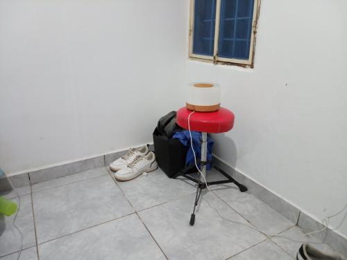un taburete rojo sentado junto a una pared con zapatos en Casa alta, en Bosconia