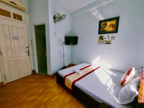 um quarto com uma cama e uma porta branca em Minh Hiền Hotel em Vung Tau