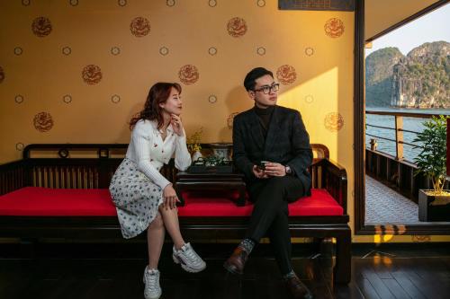 a man and a woman sitting on a bench at Nostalgia Halong Cruise in Ha Long