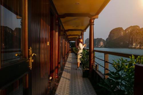 a woman standing on a boat looking out at the water at Nostalgia Halong Cruise in Ha Long