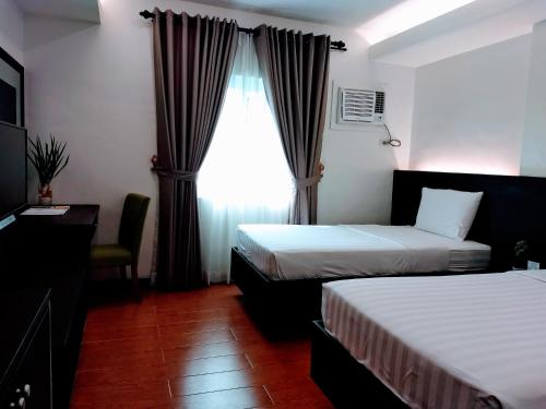a hotel room with two beds and a window at TOP STAR HOTEL OTON in Oton