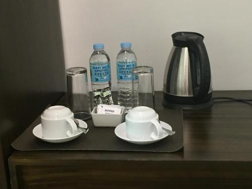 TOP STAR HOTEL OTON في Oton: طاولة مع كوبين وزجاجتين من الماء