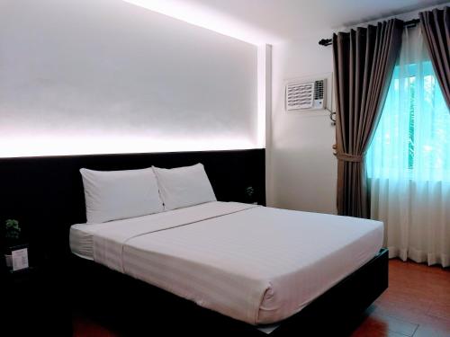 um quarto com uma grande cama branca e uma janela em TOP STAR HOTEL OTON em Oton