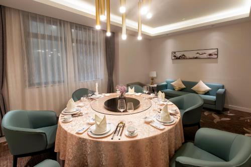a dining room with a round table and chairs at Jin Jiang West Capital International Hotel the Bell and Drum Tower Muslim quarter & Metro Line 6 & indoor swimming pool & self-service free laundry room in Xi'an