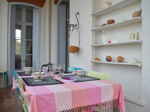 une table avec un tissu de table rose et blanc dans l'établissement Spacieux Appart 3 Chambres, Garage, Proche Port et Plage - Banyuls-sur-Mer - FR-1-225C-17, à Banyuls-sur-Mer