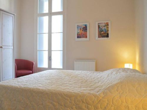 une chambre avec un grand lit blanc et une chaise rouge dans l'établissement Spacieux Appart 3 Chambres, Garage, Proche Port et Plage - Banyuls-sur-Mer - FR-1-225C-17, à Banyuls-sur-Mer