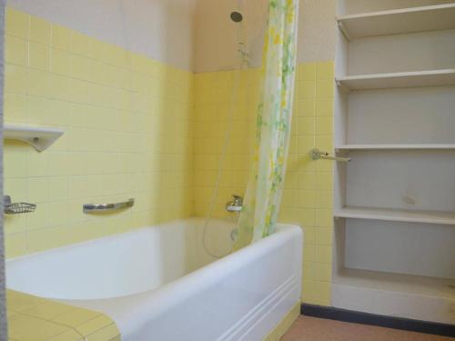 La salle de bains jaune est pourvue d'une baignoire et d'une douche. dans l'établissement Spacieux Appart 3 Chambres, Garage, Proche Port et Plage - Banyuls-sur-Mer - FR-1-225C-17, à Banyuls-sur-Mer