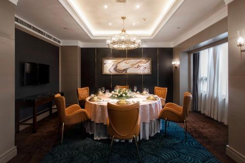 a dining room with a table and chairs and a chandelier at Jin Jiang West Capital International Hotel the Bell and Drum Tower Muslim quarter & Metro Line 6 & indoor swimming pool & self-service free laundry room in Xi'an