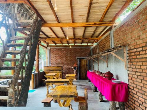 um quarto com mesas e cadeiras e uma parede de tijolos em Ruins View Holiday Resort em Pollonaruva