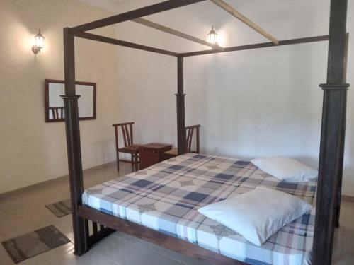 a bedroom with a canopy bed in a room at Candle House in Kalutara North
