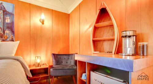een slaapkamer met een bed en een stoel in een kamer bij Maison Cadorette in Saint-Jean-des Piles