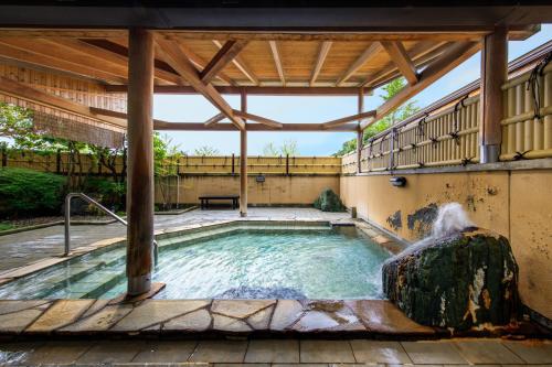 a swimming pool with a fountain in a house at Hotel Winery Hill in Izu