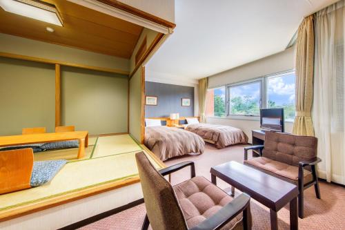 a hotel room with two beds and a desk at Hotel Winery Hill in Izu