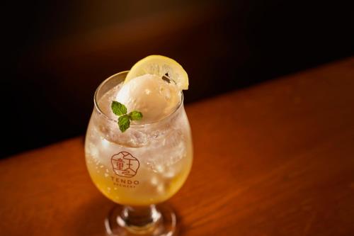 a glass with ice cream and a lemon on a table at Ichiraku tendo spa & brewery in Tendo