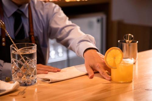 a man sitting at a table with a glass of orange juice at Ichiraku tendo spa & brewery in Tendo